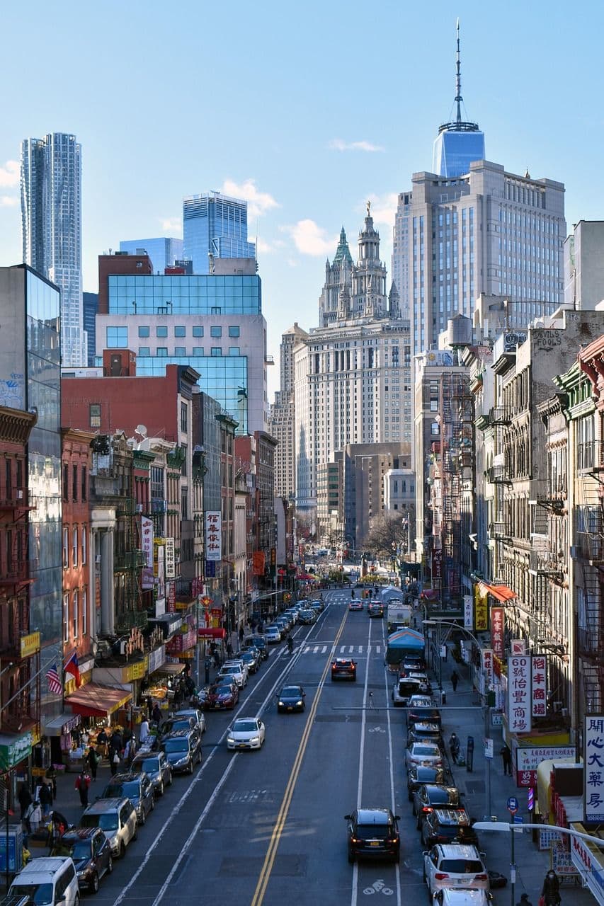 Aerial view of lower manhattan, chinatown. clear morning light, some cars on the road, one is double parked in the bike lane
